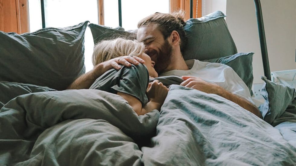 Happy couple cuddling in bed